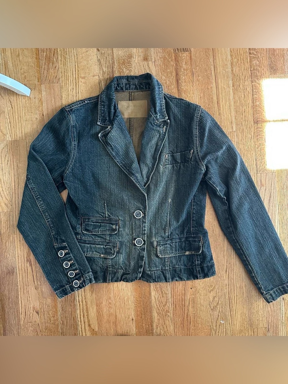 Y2K-style washed denim blazer with a two-button closure and distressed details